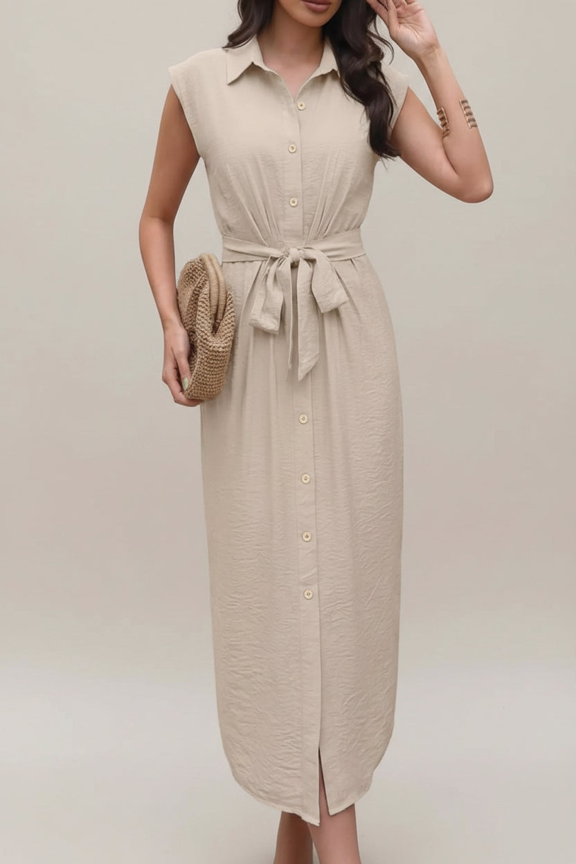 Woman wearing a beige dress holding a straw bag against a neutral background
