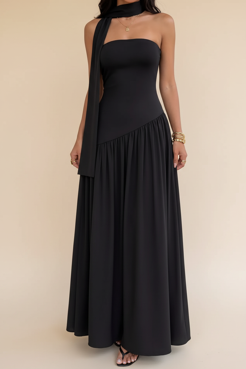 Woman wearing a black strapless dress with a flowing skirt in an outdoor setting.