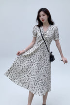 Woman wearing a floral dress against a plain background